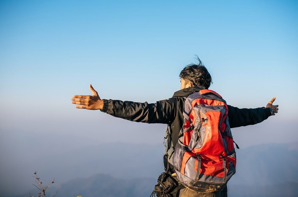 Man traveling with backpack hiking in mountains
